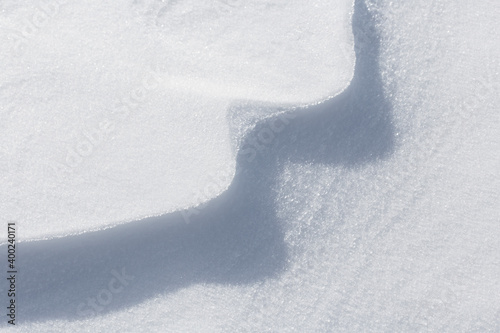 Abstract natural background. Snowy surface with stripes. Snow drift. Snowfall.