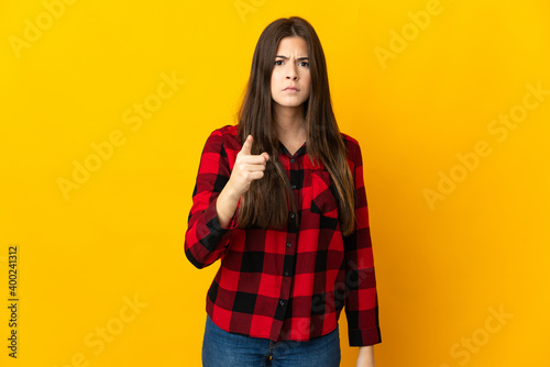 Teenager Brazilian girl isolated on yellow background frustrated and pointing to the front © luismolinero