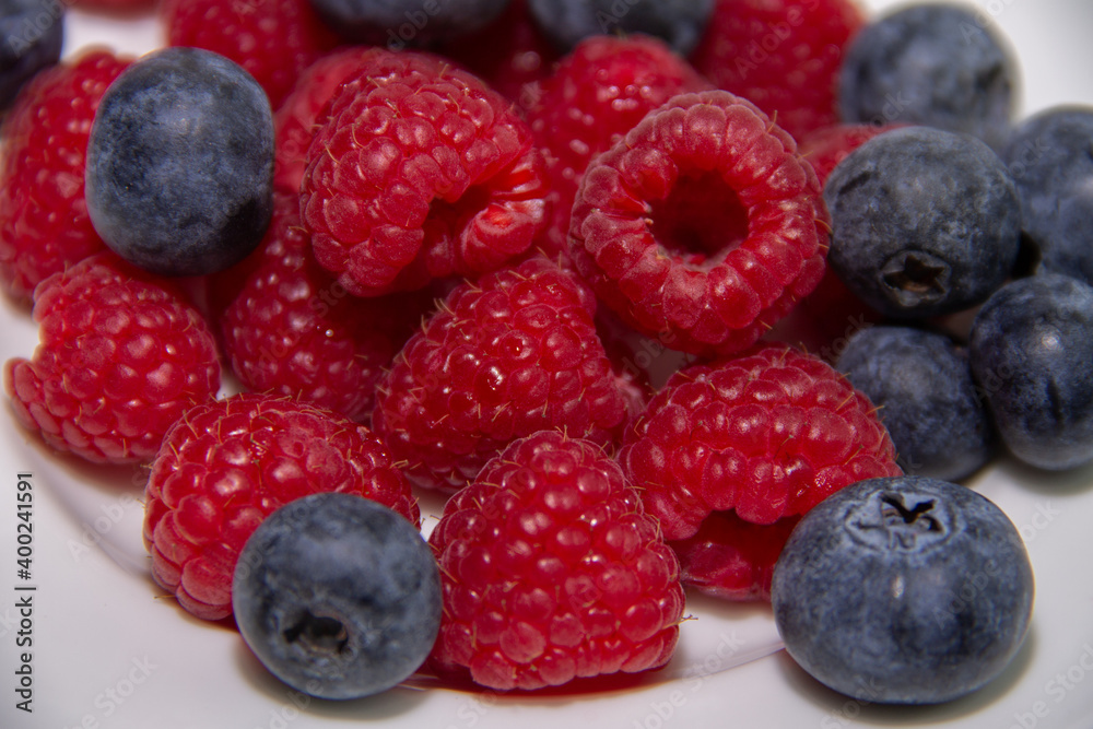ripe red raspberries and dark blue blueberries ripe red raspberries and dark blue blueberries