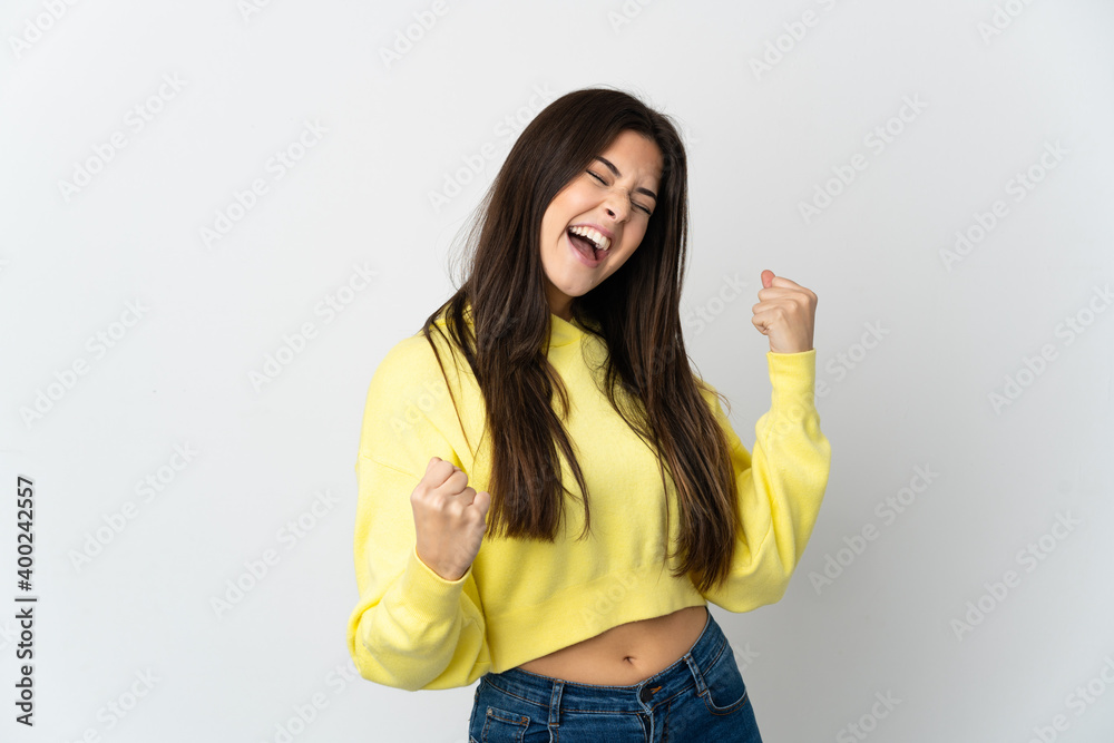 Teenager Brazilian girl isolated on white background celebrating a victory