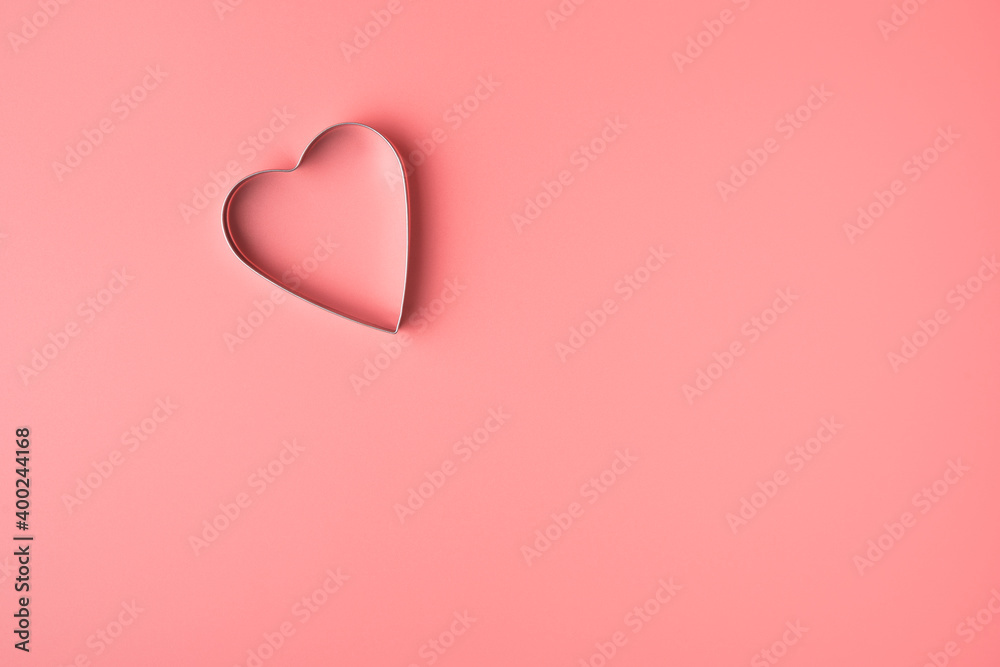 Metal heart on pink background. Top view with space to copy. Concept of February 14, love.
