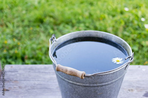 Bucket with water on the wooden boards