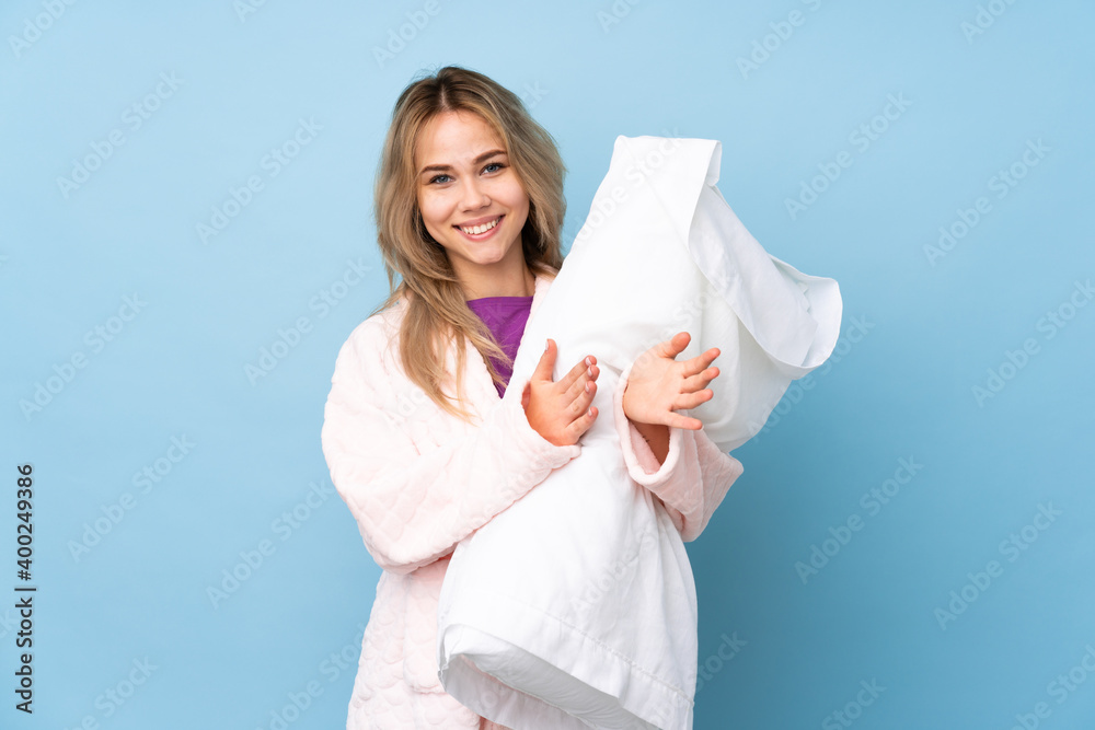 Teenager Russian girl in pajamas isolated on blue background applauding after presentation in a conference Teenager Russian girl in pajamas isolated on blue background applauding after presentation in a conference