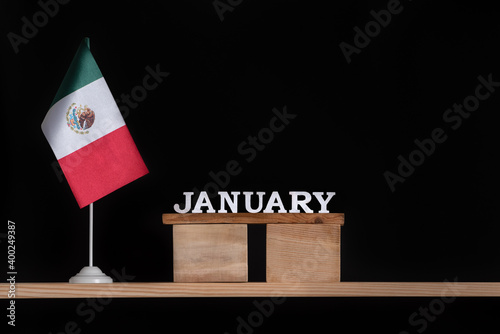Wooden calendar of January with Mexico flag on black background. Holidays of Mexico in January.