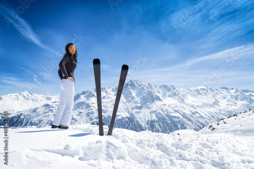 Woman with ski during sunny day in high mountains
