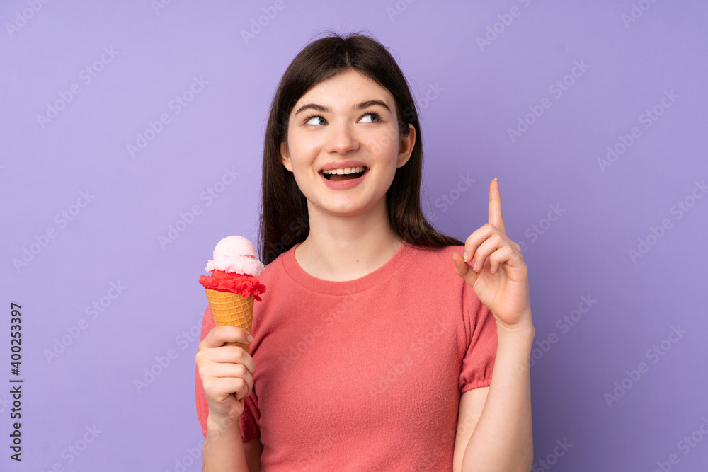 Young Ukrainian teenager girl holding a cornet ice cream over isolated purple background pointing up a great idea Young Ukrainian teenager girl holding a cornet ice cream over isolated purple background pointing up a great idea