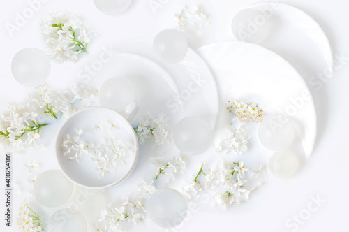 Flowers of white lilac and tea utensils in milk