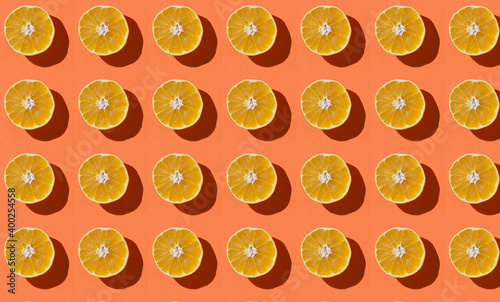 Fruit pattern of fresh orange slices on an orange background