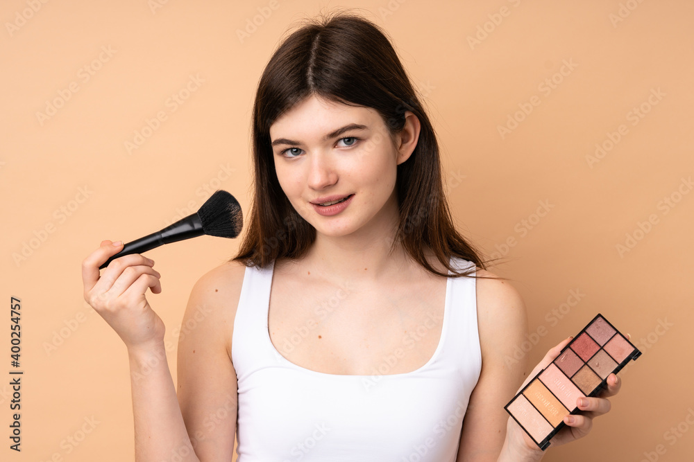 Young Ukrainian teenager girl over isolated background with makeup palette Young Ukrainian teenager girl over isolated background with makeup palette