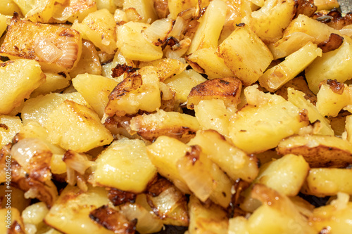 Closeup of appetizing fried potatoes with onions on a frypan. Shallow dept of field. Selective focus.
