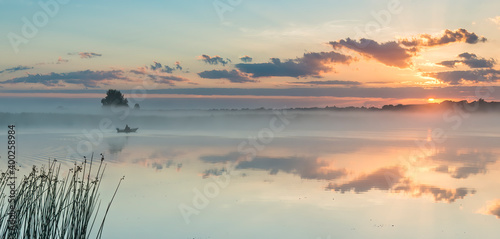 Sunrise  on the river with boat of fisherman