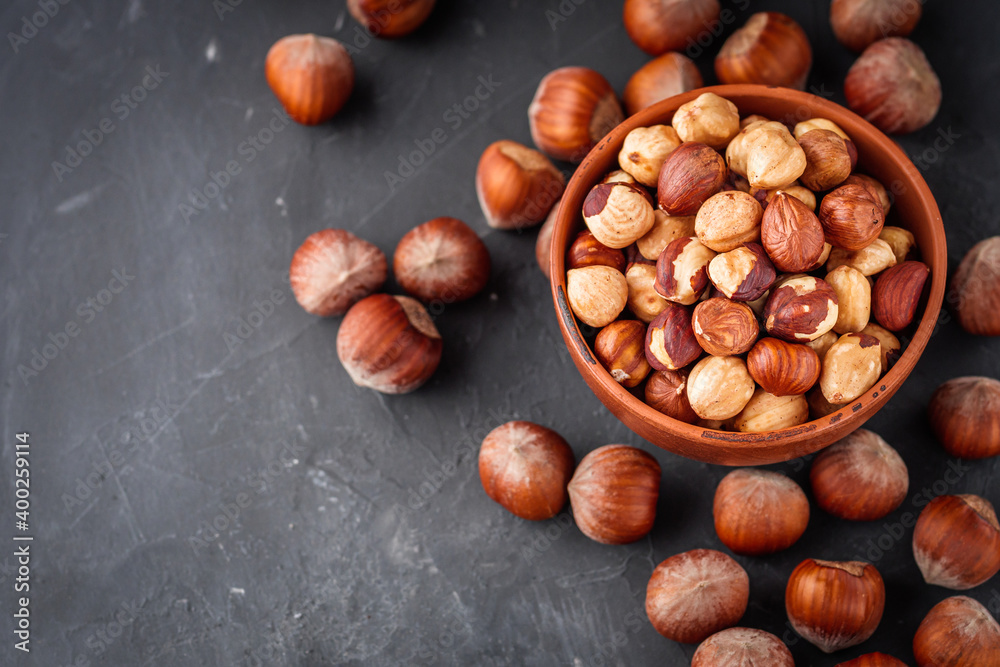 Fototapeta premium fresh natural hazelnuts on a dark stone background