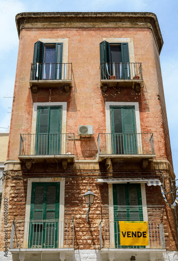 sale sign on an old tall and very narrow house in Bari, Italy