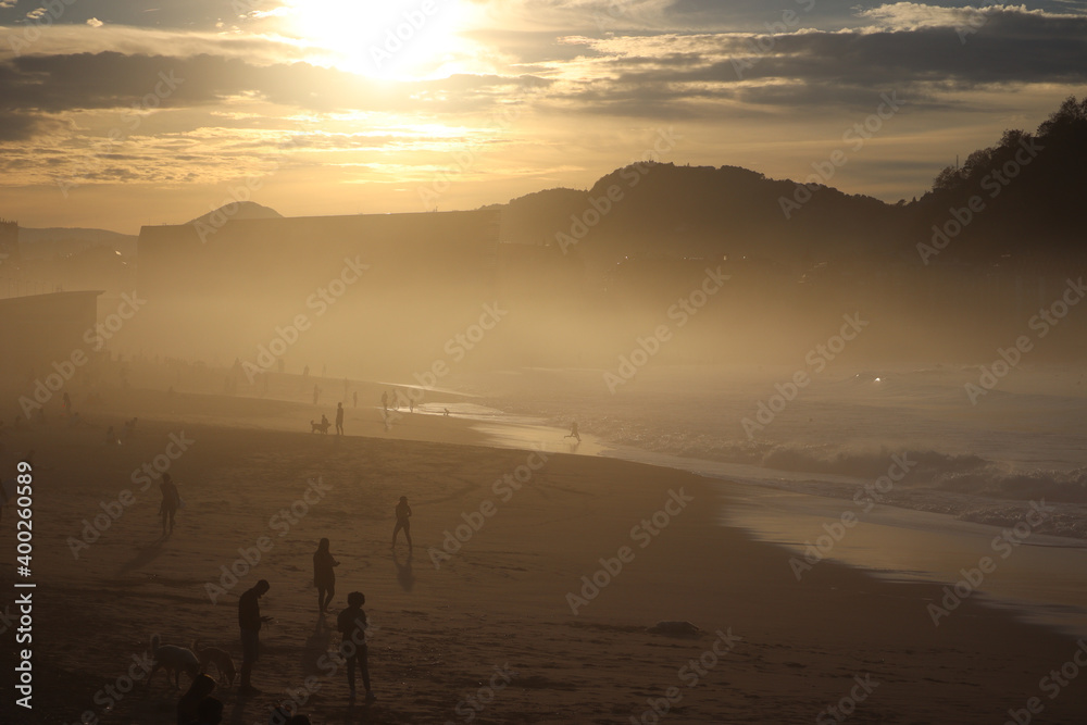A beach at sunset and covered in fog