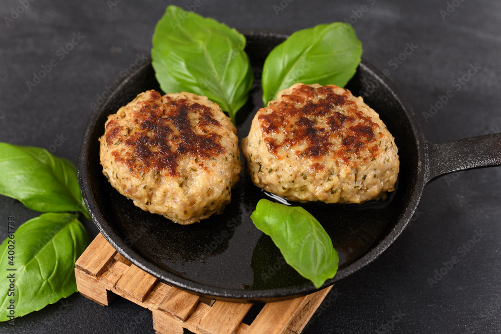 Fried meatball in a frying pan on a woodenpalet trivet, with basil leaves. Fried meatball in a frying pan on a woodenpalet trivet, with basil leaves.