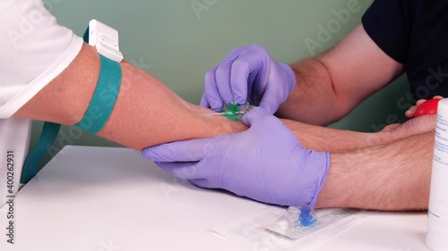Intravenous cannulation procedure. Nurse or doctor inserting cannula needle. Making injection in hospital. Blood donation concept. Injection for blood collection photo