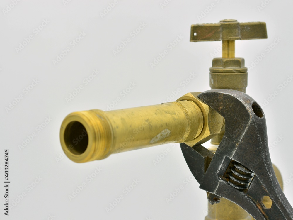 Llave ajustable apretando una tuerca en una instalación de tuberías de agua