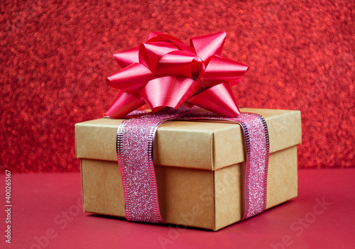 surprise gift with red bow on bokeh background for winter holiday © Sheviakova