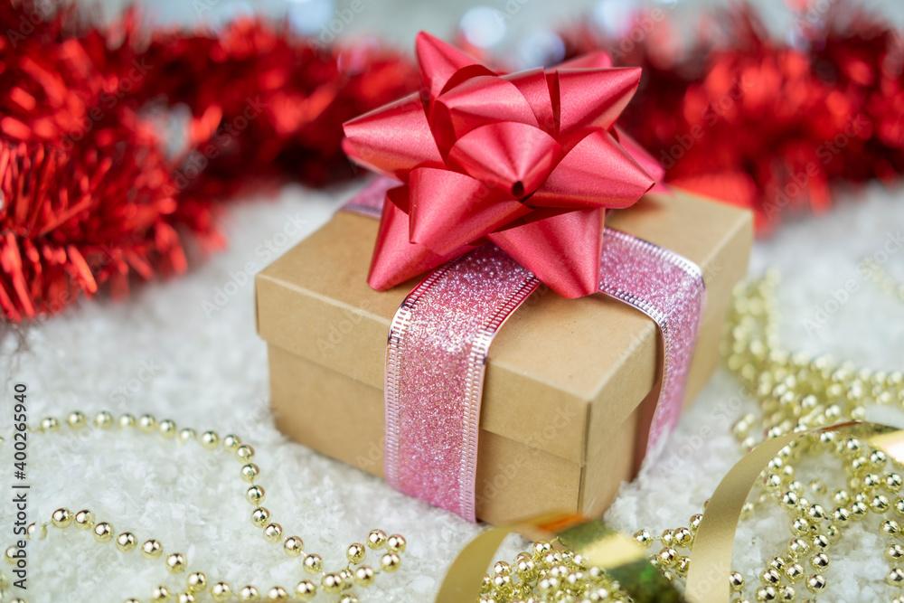 surprise gift with a red bow on the snow or the new year winter holiday and valentine's day with a golden serpentine surprise gift with a red bow on the snow or the new year winter holiday and valentine's day with a golden serpentine