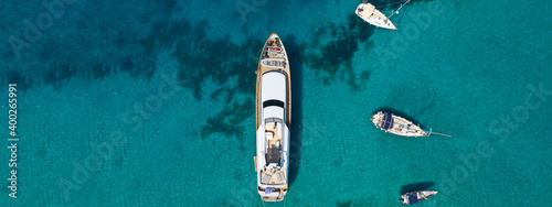 Aerial drone ultra wide top down photo of luxury yacht anchored in tropical exotic bay with emerald crystal clear sea © aerial-drone