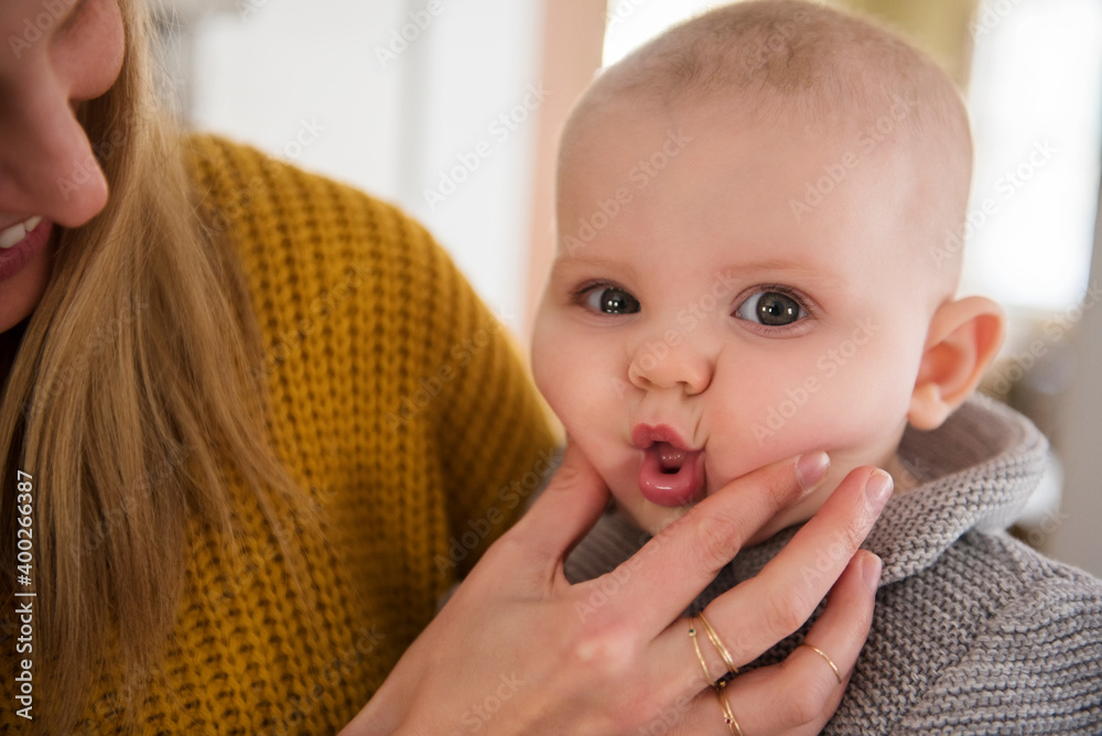 Mother squeezing baby's (12-17 months) face Mother squeezing baby's (12-17 months) face