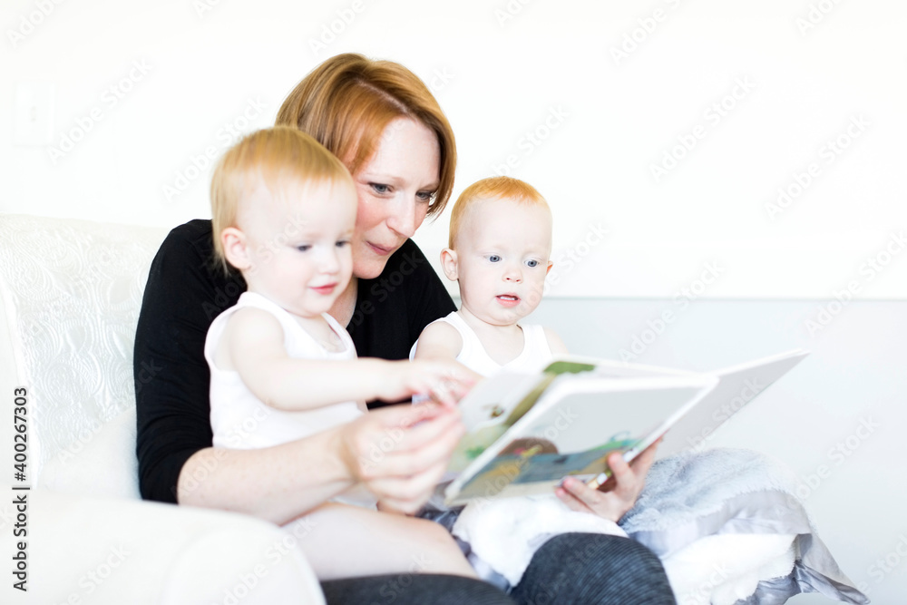 Mother and sons (12-17 months) reading picture book Mother and sons (12-17 months) reading picture book