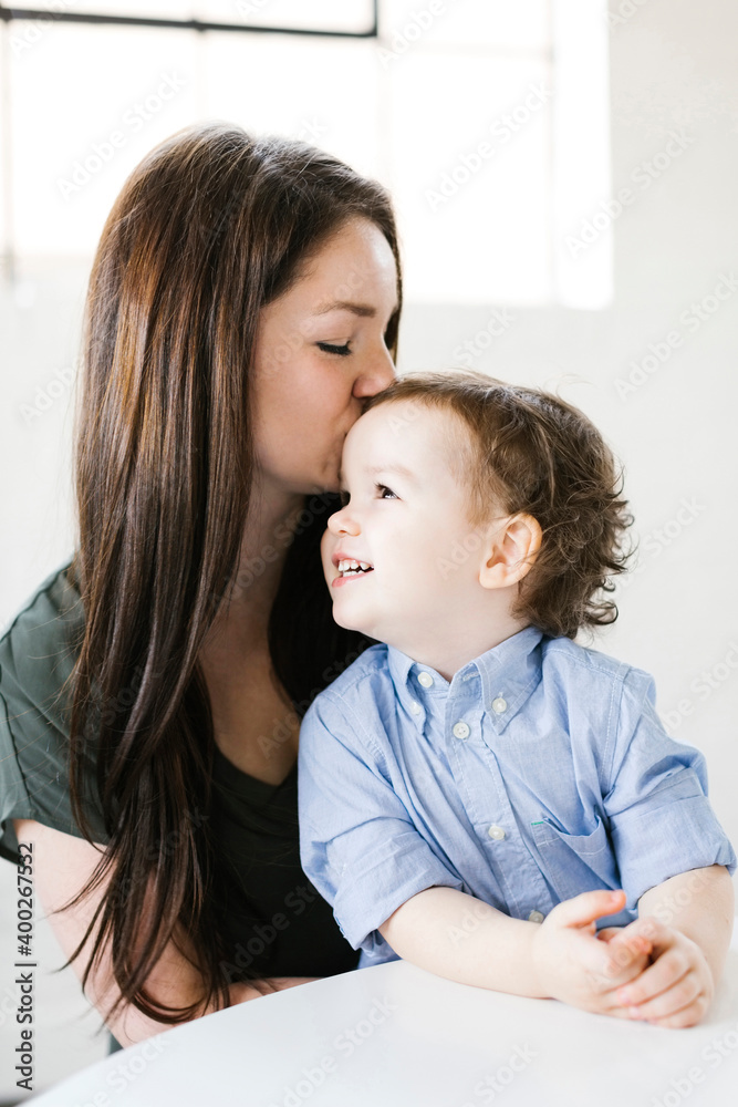 Mother giving son (4-5) forehead kiss Mother giving son (4-5) forehead kiss