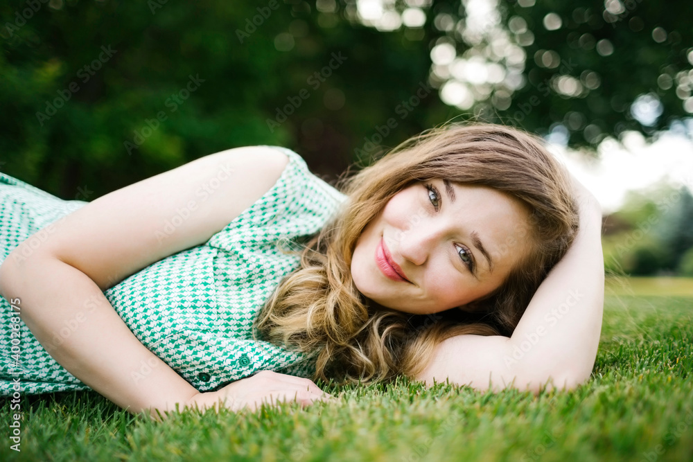 Portrait of woman lying on grass and smiling Portrait of woman lying on grass and smiling