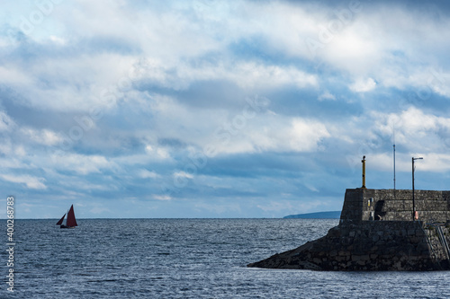 Ireland, Galway County, Spiddal, Hooker sailboat and pier photo