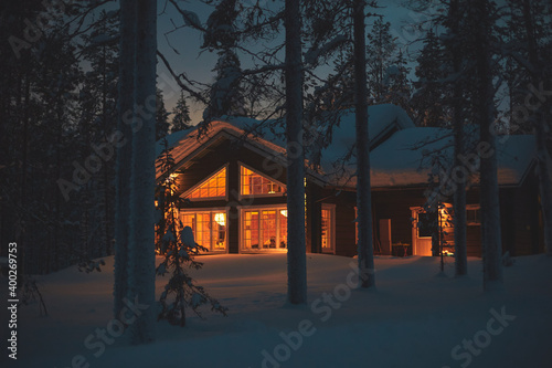 Fotobehang A night view of cozy wooden scandinavian cabin cottage chalet house covered in s