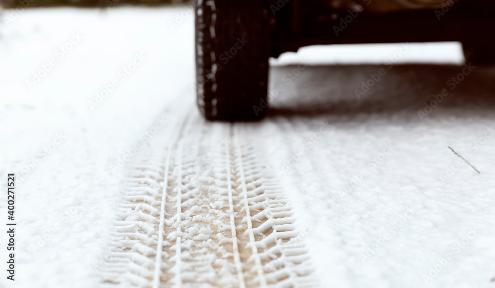In the snow, a trace of a car tire tread. Riding in winter