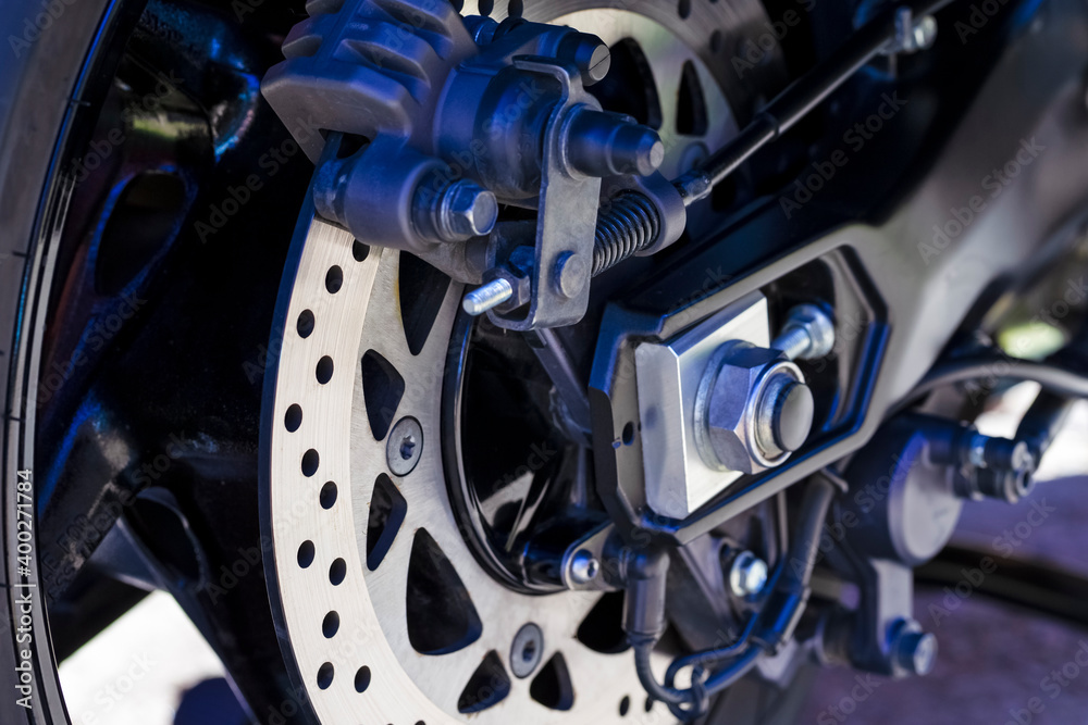 Macro Shoot of Motorcycle Rear Wheel Brake Disk With ABS Sensor and Braking Pistons.