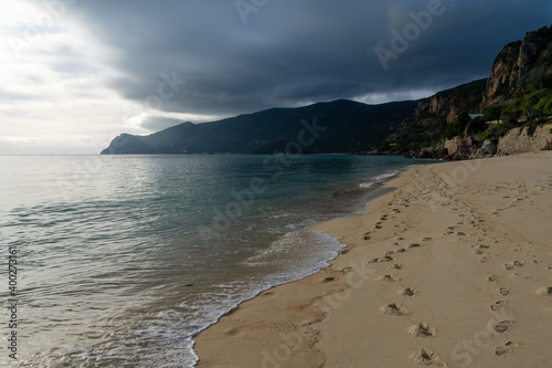 bad weather moving over mountains onto the ocean and beautiful golden beach photo
