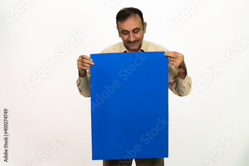 Man holding billboard in his hand. The man is dressed in a yellow shirt and cloth trousers. Isolated image on white background.