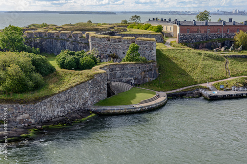 Young people are waving with hands to passing cruiseferry at the main symbol of Suomenlinna - Kuninkaanportti (King's Gate) - the principal entrance to the fortress.
