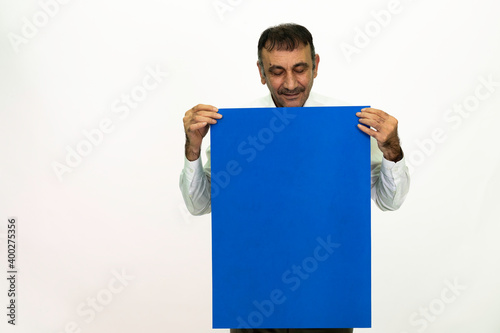 Man holding a blue banner in his hand. It can be written on. She is dressed in a white shirt and fabric pants. Isolated image white background.
