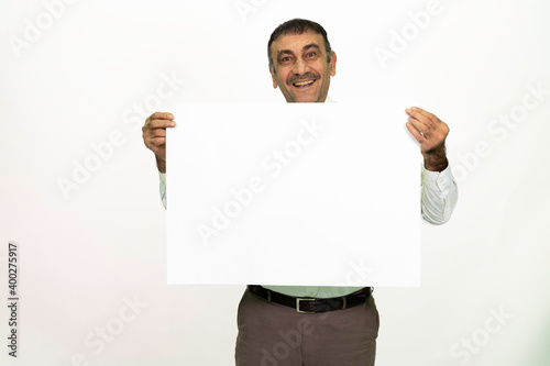 Man holding a white banner in his hand. It can be written on. She is dressed in a white shirt and fabric pants. Isolated image white background.