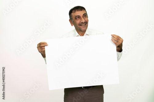 Man holding a white banner in his hand. It can be written on. She is dressed in a white shirt and fabric pants. Isolated image white background.