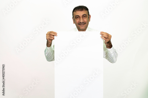 Man holding a white banner in his hand. It can be written on. She is dressed in a white shirt and fabric pants. Isolated image white background.