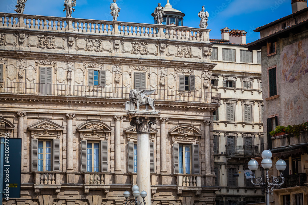 Obraz premium Statue of Lion of St Mark and Pallazo Maffei at Piazza delle Erbe in Verona, Italy