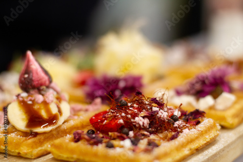 Waffles on board decorated with bananas and strawberries
