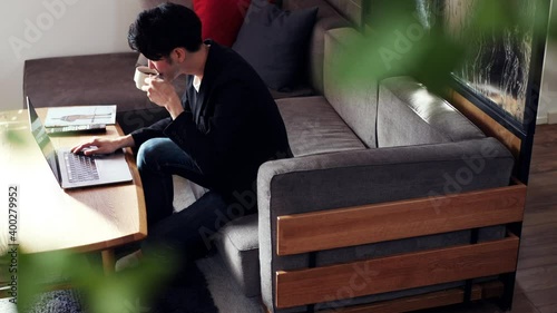 リビングのソファでテレワークをする男性