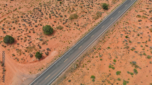 Countryside road through the fabulous Monument Valley in summser season, aerial view from drone