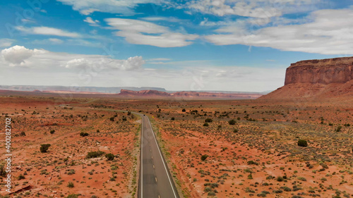 Countryside road through the fabulous Monument Valley in summser season, aerial view from drone photo