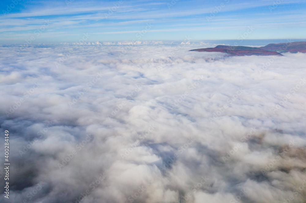Aerial view of mountains poking through a sea of fog and low cloud in a rural setting
