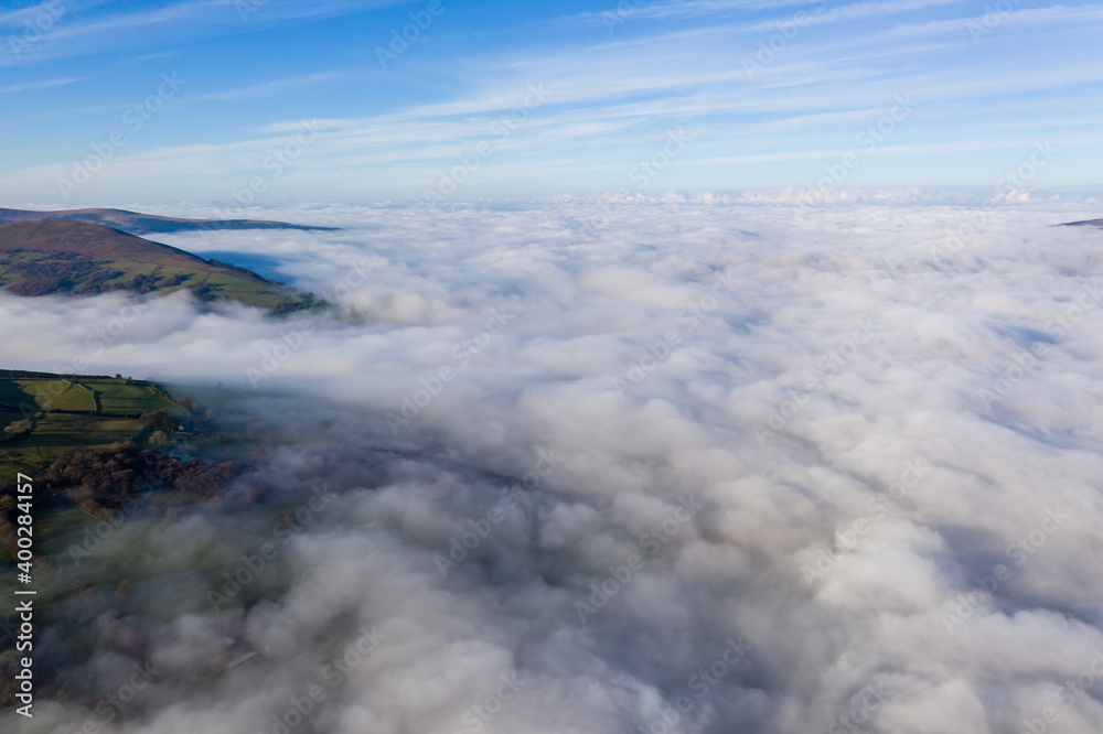 Aerial view of mountains poking through a sea of fog and low cloud in a rural setting