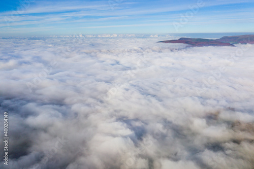 Aerial view of mountains poking through a sea of fog and low cloud in a rural setting