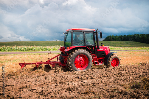 Fotografia Farmer in tractor preparing land for sowing, plowing the field