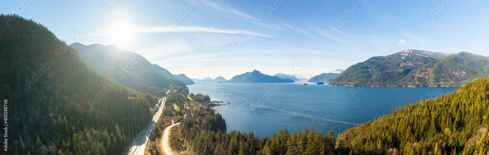 Aerial panoramic view of the Sea to Sky Highway in Howe Sound, North of Vancouver, British Columbia, Canada. Taken during a sunny winter day.
