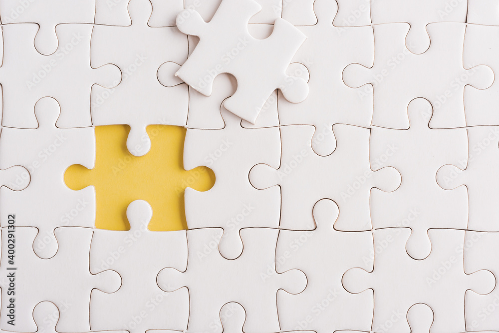 Top view flat lay of paper plain white jigsaw puzzle game texture incomplete or missing piece, studio shot on a yellow background, quiz calculation concept Top view flat lay of paper plain white jigsaw puzzle game texture incomplete or missing piece, studio shot on a yellow background, quiz calculation concept